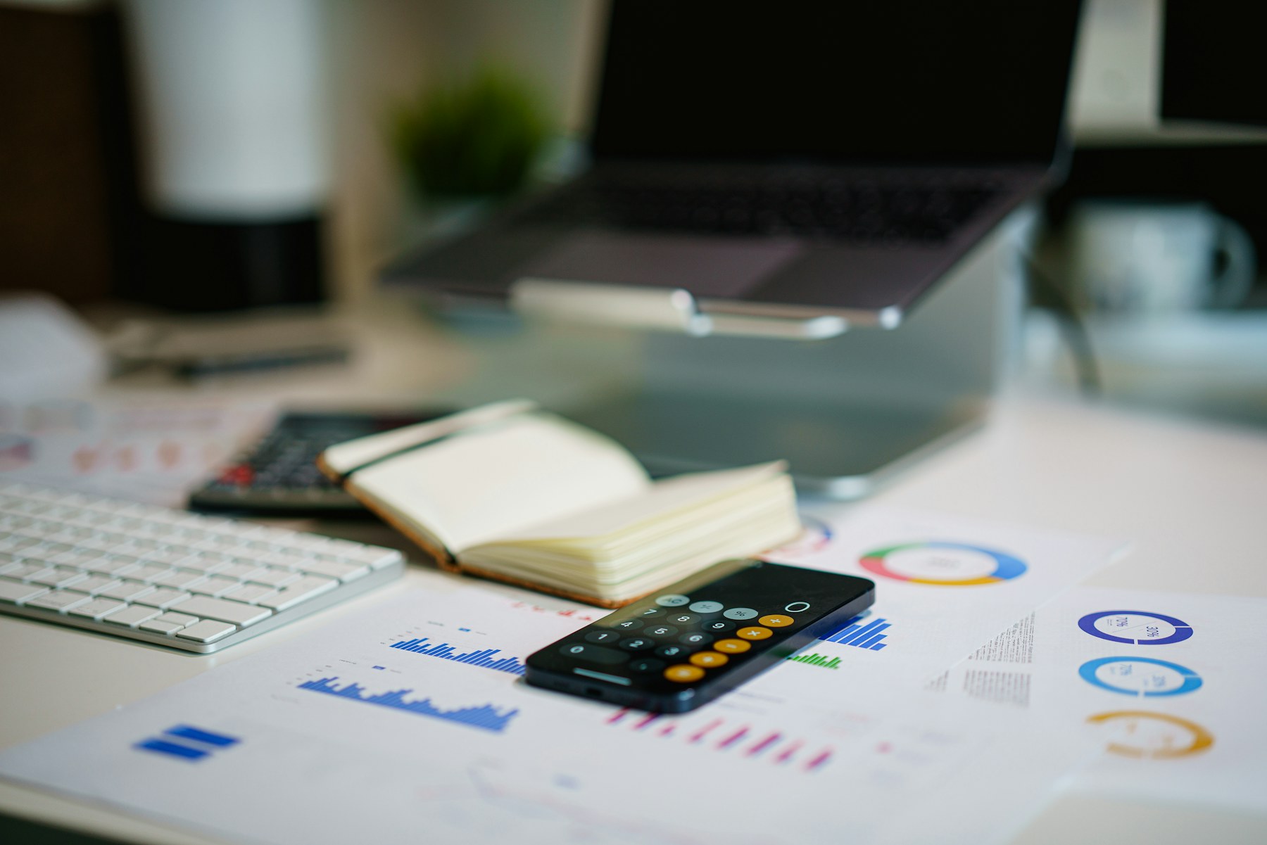 Arbeitsplatz mit Kostenübersichten und Taschenrechner für die Mobilfunk-Kostenanalyse